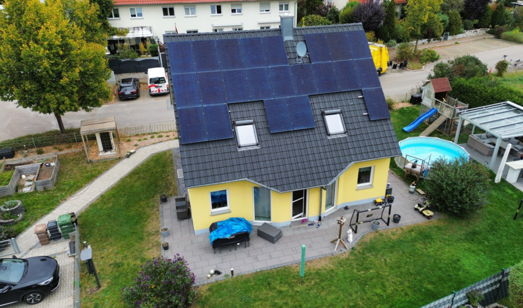 Luftaufnahme eines Einfamilienhauses mit großflächiger Photovoltaikanlage auf dem Dach