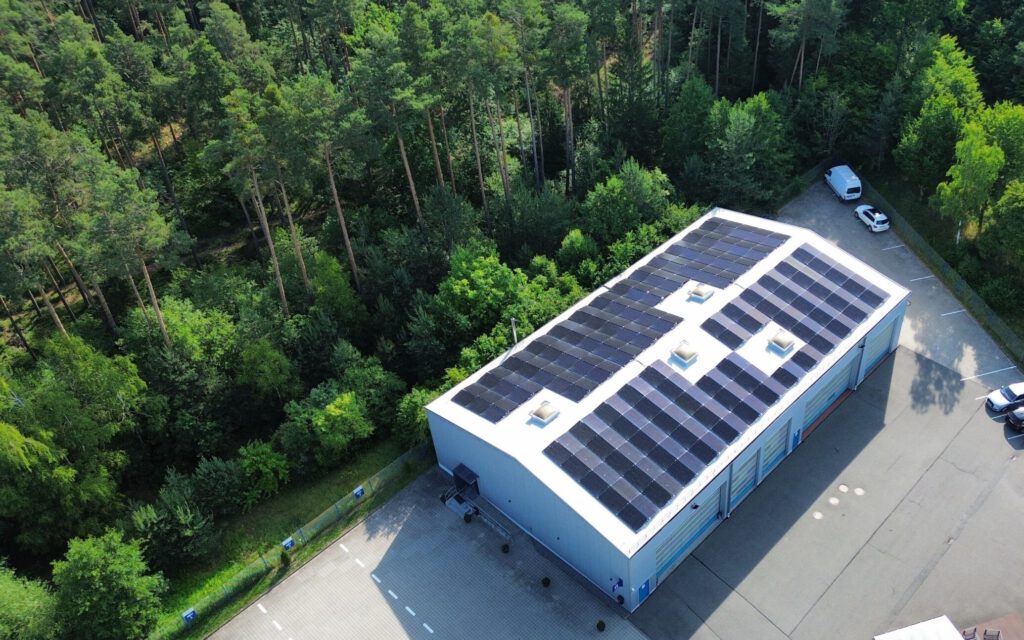 Lagerhalle einer Firma mit großflächiger Photovoltaikanlage auf dem Dach