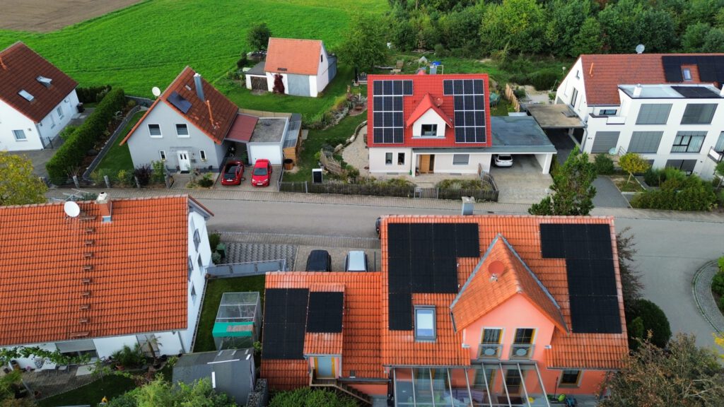 Photovoltaikanlage auf einem roten Ziegeldach eines Wohnhauses