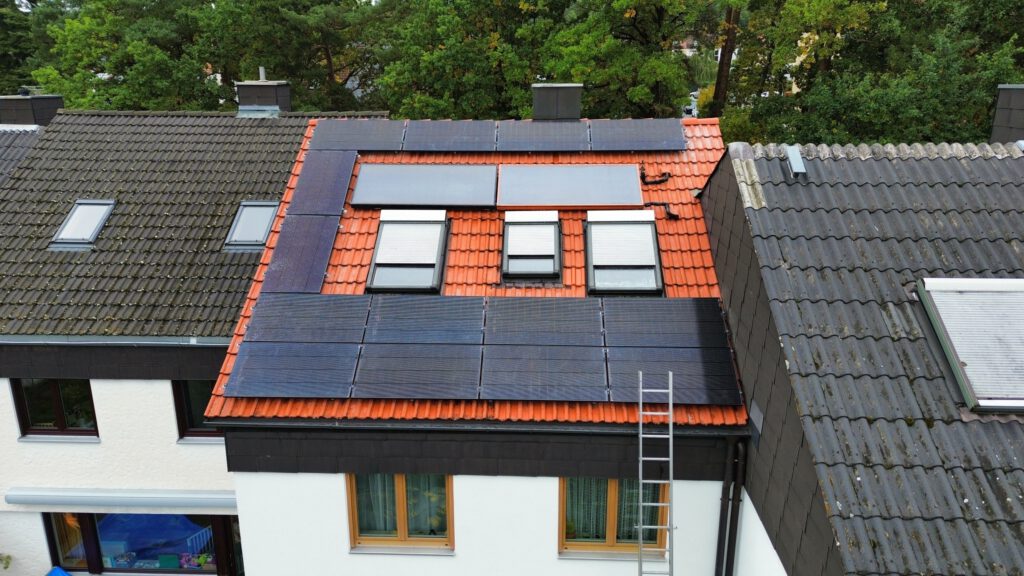 Wohnhaus mit installierter Photovoltaikanlage auf dem Dach und Wechselrichtern im Innenbereich
